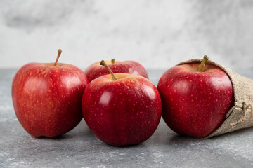 Delicious red apples out of burlap on marble background