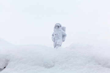 Statuette of an astronaut confidently explores alien planet's surface. Cold planet covered with...