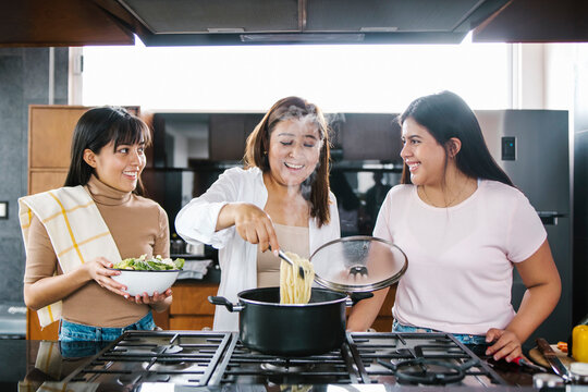 hispanic mother and daughter cooking at home in Mexico city