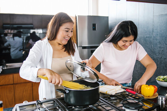 mexican mother and daughter cooking at home in Mexico city
