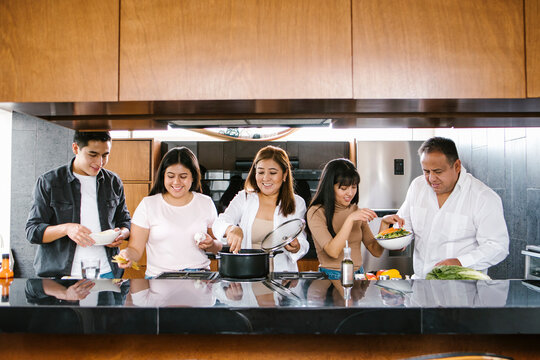 latin family in the kitchen cooking together. Healthy food at home in Latin America