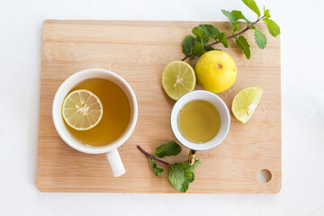 herbal healthy drinks hot tea honey lemon for health care with peppermint leaf and lemon slice for relaxation arrangement flat lay style on background wooden