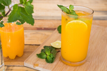 herbal healthy drinks cold orange juice for health care with peppermint leaf and lemon slice arrangement flat lay style on background wooden