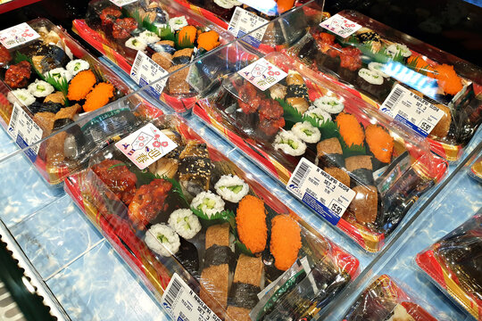Various sushi set in take away box selling in Aeon Mall. Sushi is a Japanese dish of prepared vinegared rice, accompanying with seafood and vegetables. PENANG, MALAYSIA - 19 FEB 2021.
