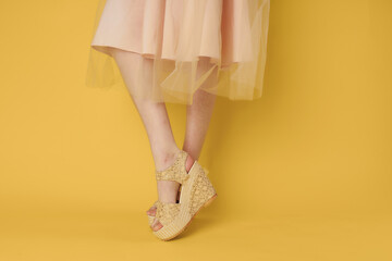 Woman in dress legs shoes attractive look yellow background fashion
