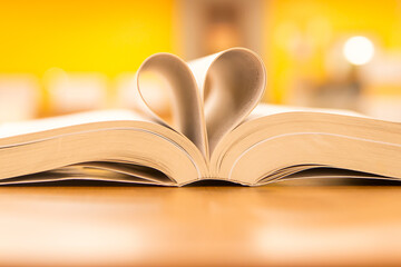 Close up page of a book in heart vintage style on the table at library room of lifestyle love to read and reading a text book and February valentine day concepts.