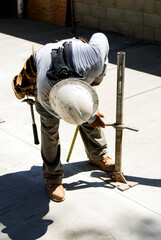 Construction worker adjusting a steel support leg