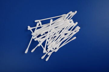 a pile of cotton swabs lies on a blue background