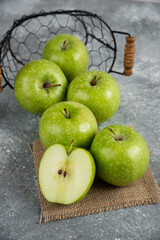 Metal bucket of fresh green apples on marble background