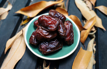 Close up fruits of date palm on black table.