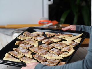 Hands of a woman preparing butter biscuits sprinkled with cinnamon and sugar. Homemade food.