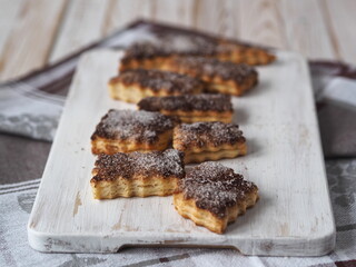 Butter biscuits sprinkled with cinnamon and sugar on a kitchen cutting board. Home cooking.