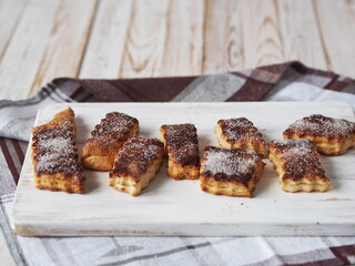Butter biscuits sprinkled with cinnamon and sugar on a kitchen cutting board. Home cooking.