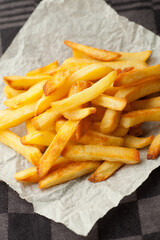 Home made oven baked french fries on kitchen paper. Fast, unhealthy food.