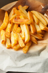 Home made oven baked french fries on kitchen paper. Fast, unhealthy food.