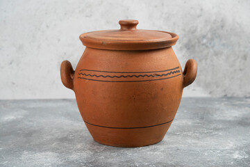 Single clay antique vase placed on marble surface
