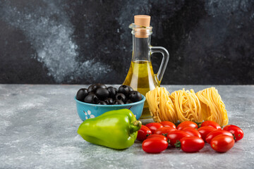 Noodles, oil and various vegetables on stone table