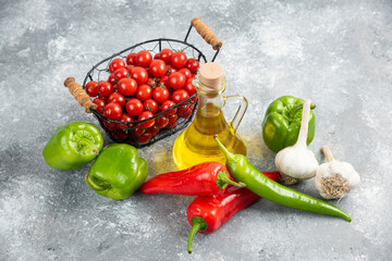 Cherry tomatoes in basket with chili peppers, garlic and olive oil