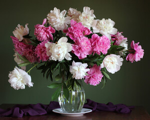 white and pink peonies in a glass jar.
