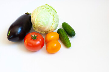 Fresh vegetables, cabbage, eggplant, red and yellow tomatoes and cucumber on a white background