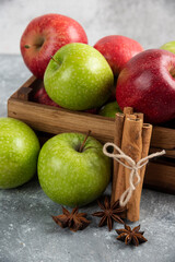 Whole delicious green and red apples in wooden box