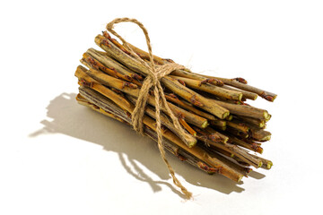 a bundle of twigs tied with a hemp rope on a white background