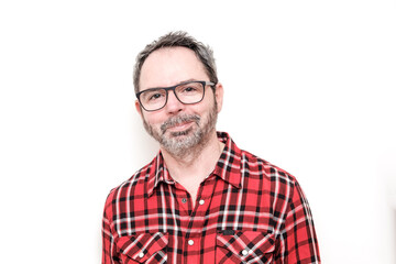 Obraz premium Portrait of a smiling mature man with beard wearing red plaid shirt and glasses.