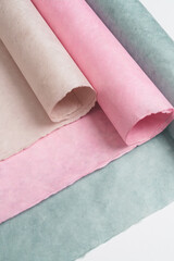 Multicolored soft pastel paper rolls in neutral tones, beige, pink, green. Copy space for text, minimalism concept