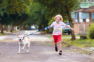 Child walking dog. Kids and puppy. Boy and pet.