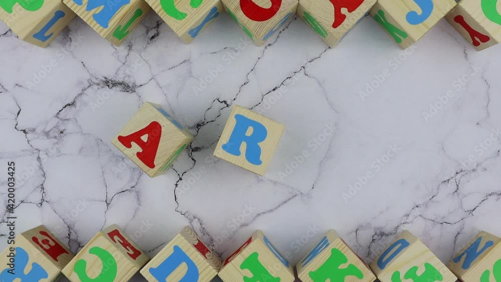 Fototapete art concept with colorful alphabet letters on wooden cubes centered between top and bottom borders o