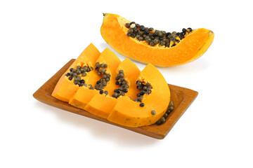 Pieces of papaya on a wooden plate and outside it isolated on white