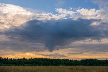 Before the rain. Thundercloud over an agricultural field on a summer evening