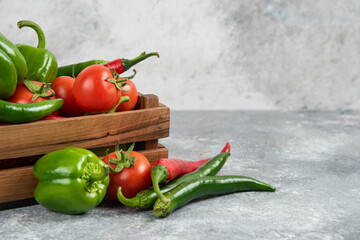Wooden box full of fresh vegetables on marble background