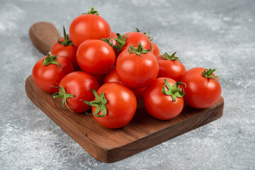 Bunch of red fresh tomatoes on wooden cutting board