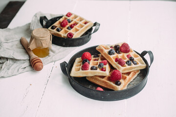 Belgian waffles with berries on a white plate. breakfast