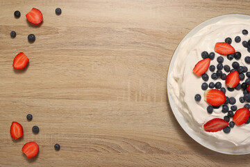 Naklejka na ściany i meble wooden background with cheesecake with strawberries and blueberries
