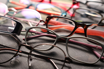 Different multi-colored eyeglass frames close-up on gray background.