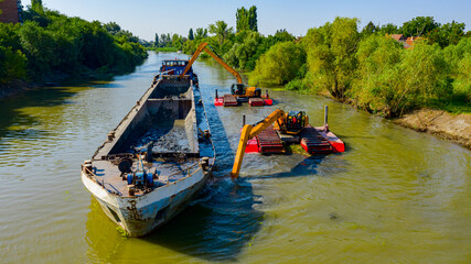 Naklejka premium Aerial view of river, canal is being dredged by excavators