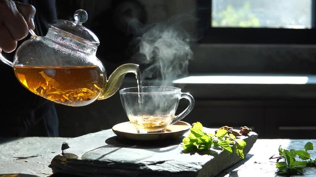 Tea being poured into tea cup. Slow motion. Breakfast concept.