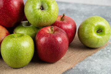 Bunch of fresh green and red apples placed on burlap