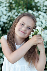 Beautiful preteen girl with long blond hair enjoy spring apple blooming. Little preschool girl in garden tree flowers.
