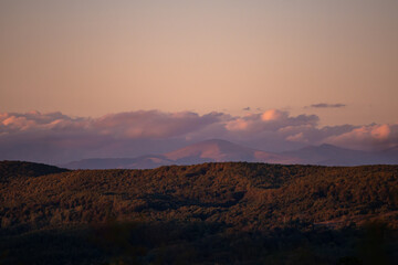 fall landscape overlooking the horizon where the ridges of the high mountains can be seen. high hills full of dense forests at sunset
