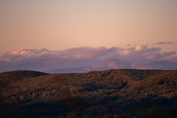 fall landscape overlooking the horizon where the ridges of the high mountains can be seen. high hills full of dense forests at sunset