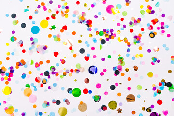 colorful paper and foil confetti wallpaper. white background. holiday new year, birthday, wedding, christmas flat lay