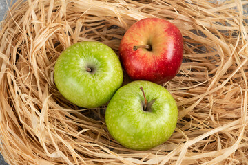 Whole delicious green and red apples in bird nest