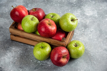 Fresh delicious green and red apples in wooden box