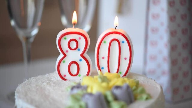 Birthday candle as number eighty 80 on top of sweet cake on the table, 80th birthday, HD