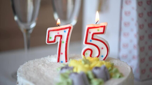 Birthday candle as number seventy five 75 on top of sweet cake on the table, 75th birthday, HD