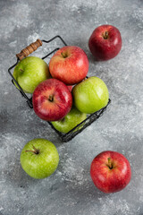 Bunch of fresh green and red apples placed in metal basket