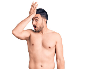 Fototapeta premium Young handsome man wearing swimwear surprised with hand on head for mistake, remember error. forgot, bad memory concept.